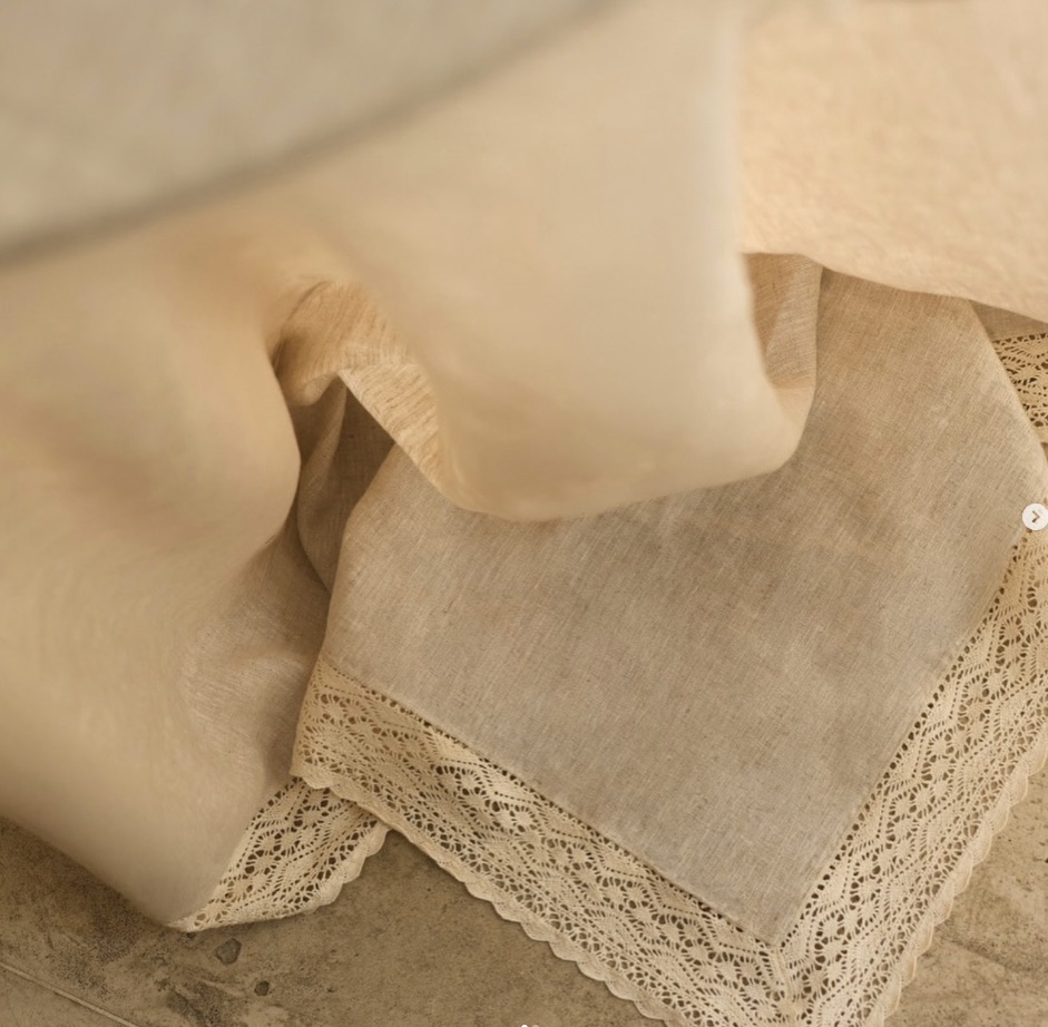Detalhe macro da bainha e da renda em peça de linho cru